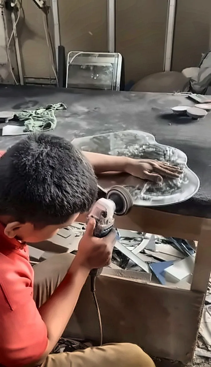 Pekerja memoles tepi kaca di workshop